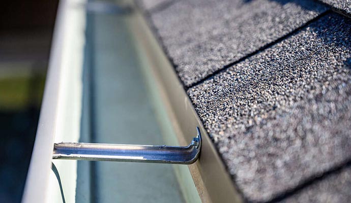 Shingles on a clean roof with clear gutters, showcasing proper maintenance and care.